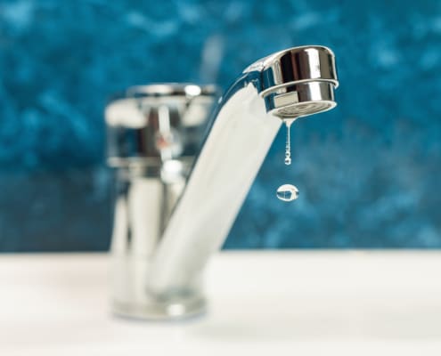 A drop of water drips from a leaky faucet